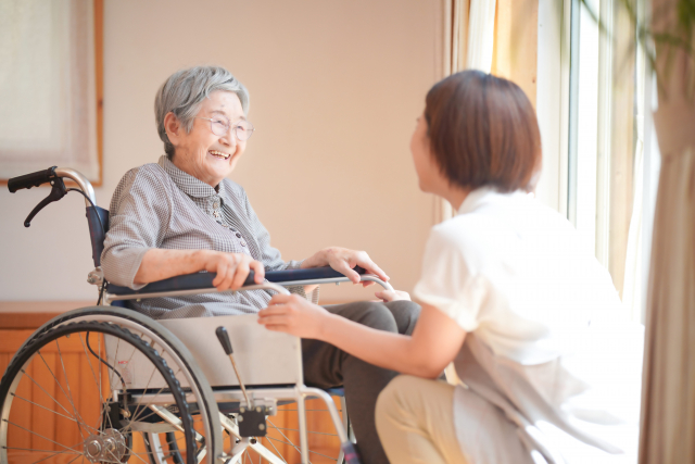 車椅子の高齢者と介護者